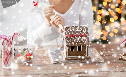 Image of close up of woman making gingerbread house at home