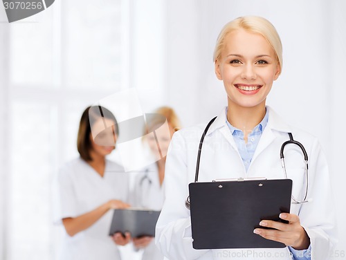 Image of smiling female doctor with clipboard
