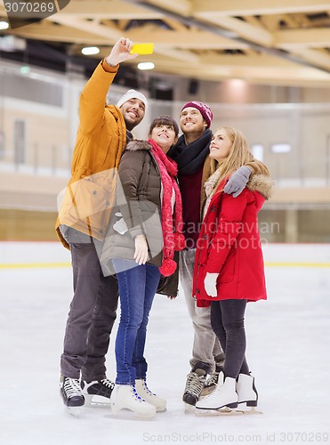 Image of happy friends taking selfie on skating rink