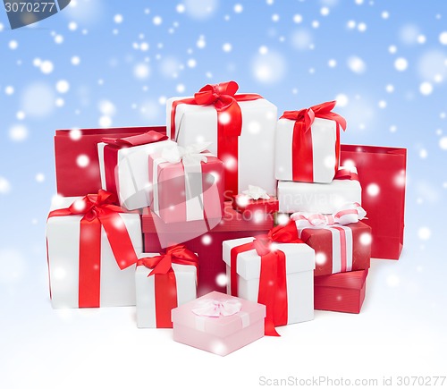 Image of christmas presents over blue background with snow