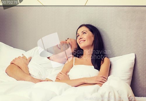 Image of happy couple dreaming in bed