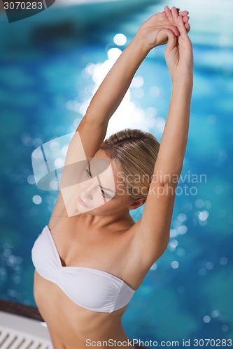 Image of happy woman sitting in jacuzzi at poolside