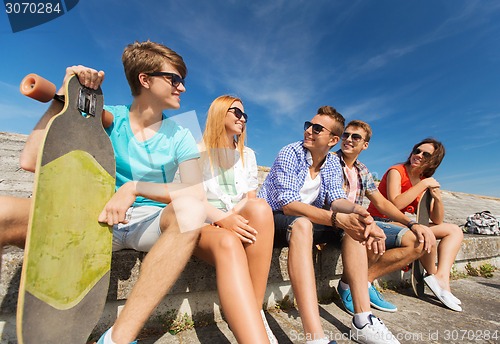 Image of group of smiling friends sitting on city street