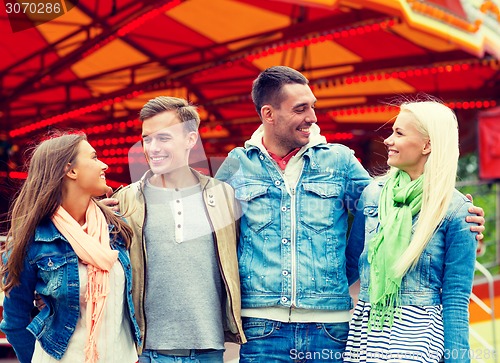 Image of group of smiling friends in amusement park