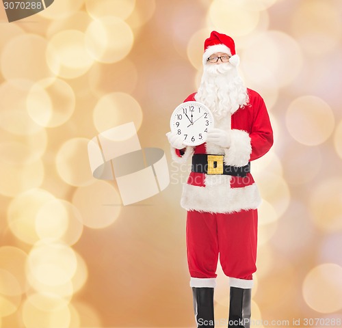 Image of man in costume of santa claus with clock