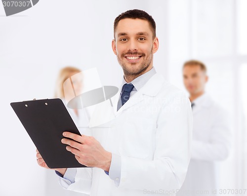 Image of smiling male doctor with clipboard