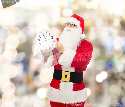 Image of man in costume of santa claus with clock