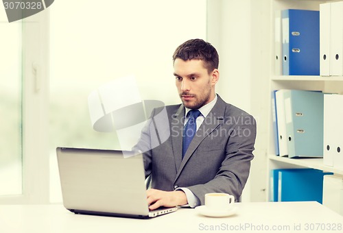 Image of busy businessman with laptop and coffee