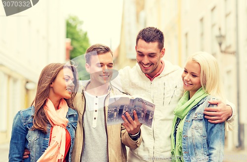 Image of group of friends with city guide exploring town