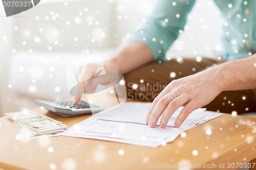 Image of close up of man counting money and making notes