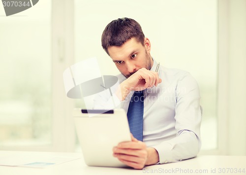 Image of stressed businessman with tablet pc and documents