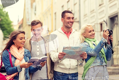 Image of group of friends with city guide, map and camera