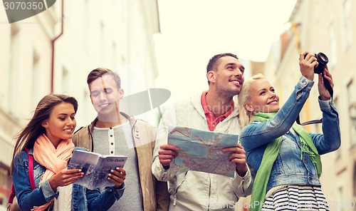 Image of group of friends with city guide, map and camera