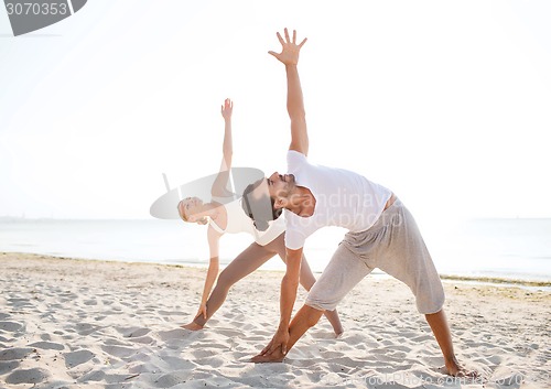 Image of couple making yoga exercises outdoors