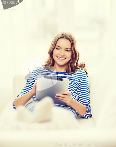 Image of smiling teenage girl with tablet pc at home