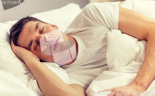 Image of handsome man sleeping in bed