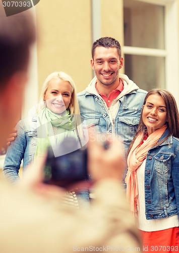 Image of group of smiling friends taking photo outdoors