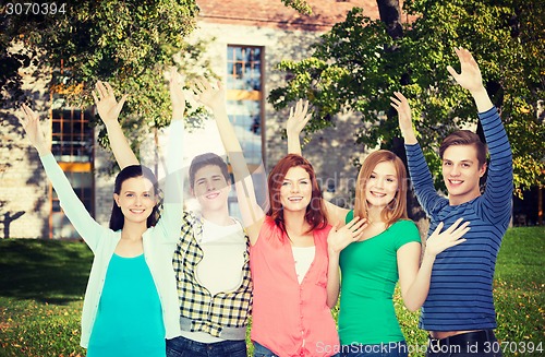 Image of group of smiling students waving hands