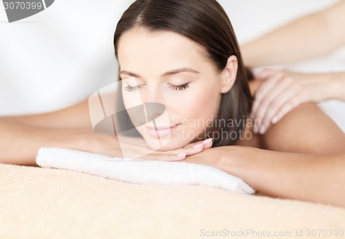 Image of beautiful woman in spa salon getting massage