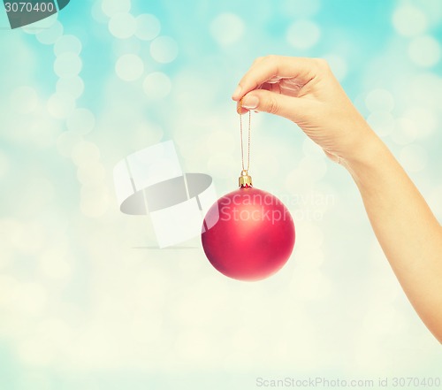 Image of close up of woman in sweater with christmas ball