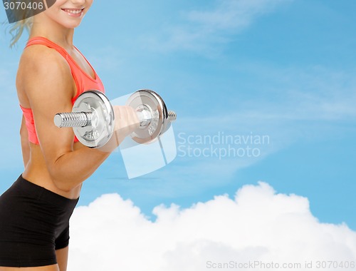 Image of close up of sporty woman with heavy steel dumbbell