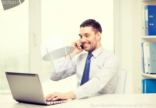 Image of businessman with laptop and smartphone at office