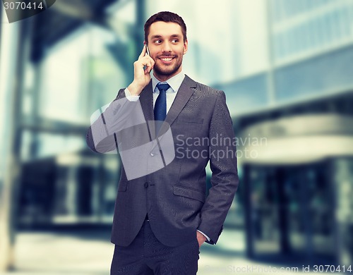 Image of young smiling businessman with smartphone