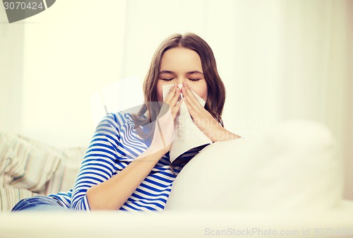 Image of sick teenage girl with paper tissue