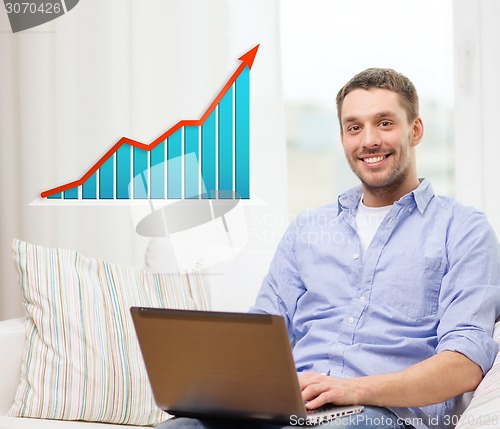 Image of smiling man with laptop and growth chart at home