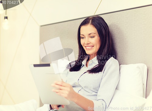 Image of happy businesswoman with tablet pc in hotel room