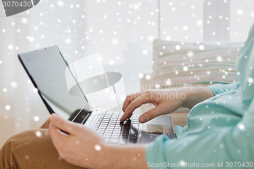 Image of close up of man working with laptop at home