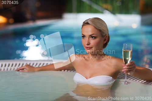 Image of happy woman drinking champagne at swimming pool