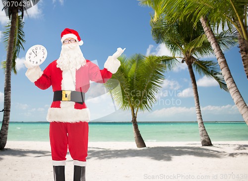 Image of man in costume of santa claus with clock