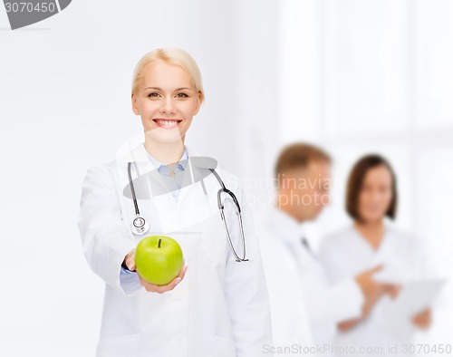 Image of smiling female doctor with green apple