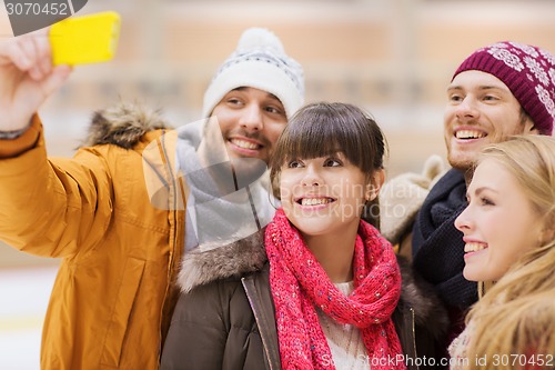 Image of happy friends taking selfie on skating rink