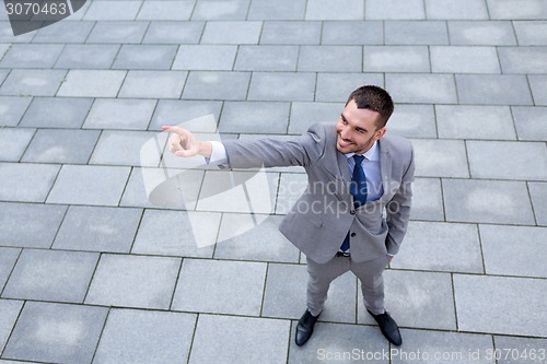Image of young smiling businessman outdoors from top