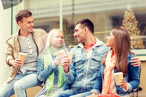 Image of group of smiling friends with take away coffee