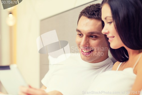 Image of smiling couple in bed with tablet pc computers