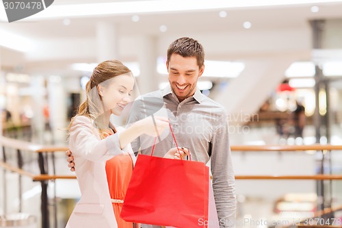 Image of happy young couple with shopping bags in mall