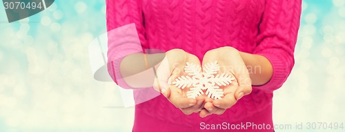 Image of close up of woman in sweater holding snowflake