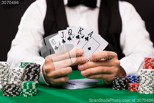 Image of poker player with cards and chips at casino