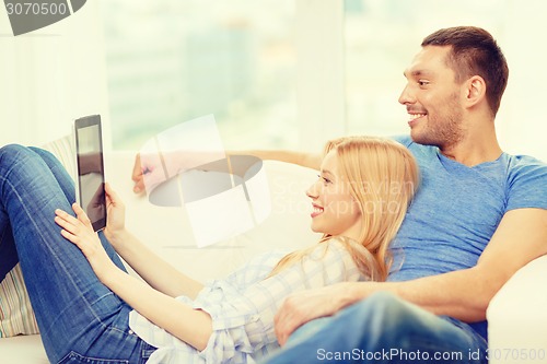 Image of smiling happy couple with tablet pc at home