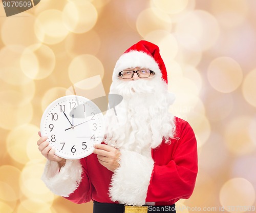 Image of man in costume of santa claus with clock