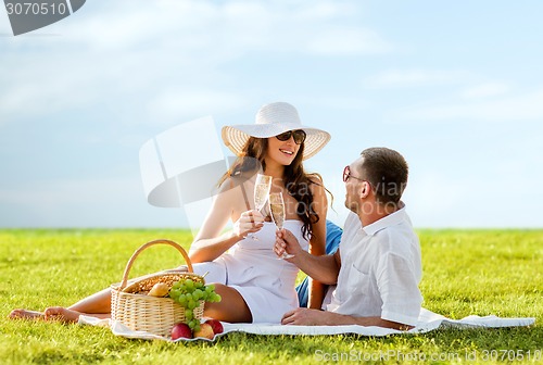 Image of smiling couple drinking champagne on picnic