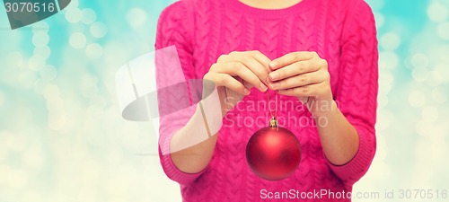 Image of close up of woman in sweater with christmas ball