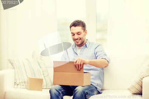 Image of man with cardboard boxes at home