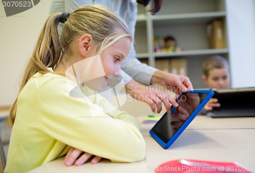 Image of little girl with teacher and tablet pc at school