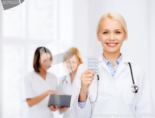 Image of smiling female doctor with pills