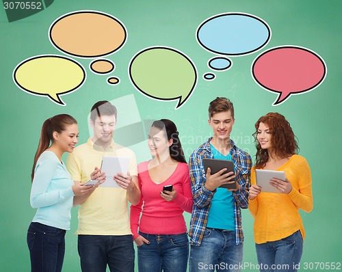 Image of group of teenagers with smartphones and tablet pc