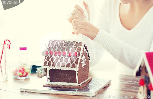 Image of close up of woman making gingerbread house at home